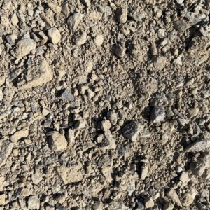 Close-up of sandy gravel and small rocks scattered on dry ground.
